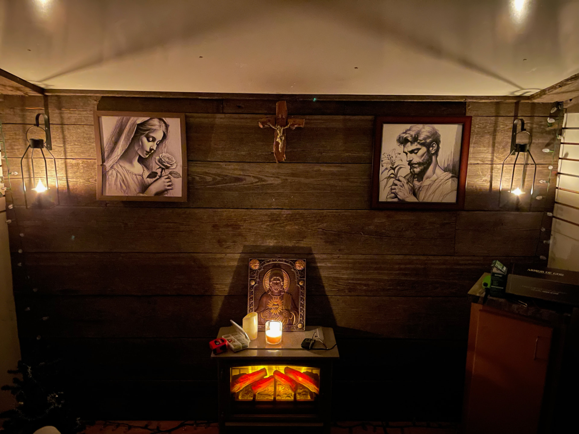 The inside of the God cave, with a crucifix above a candle-lit altar between images of Mary and St. Joseph